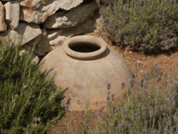 Ancienne jarre en terre cuite à demi enterrée dans un jardin méditerranéen, entre romarin et lavande : olla ou oya, la même jarre d'arrosage